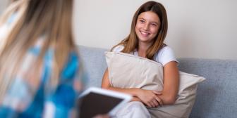 Junges Mädchen sitzt auf der Couch während einer Beratung